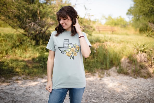 Micah wearing a sage Texas wildflower tee