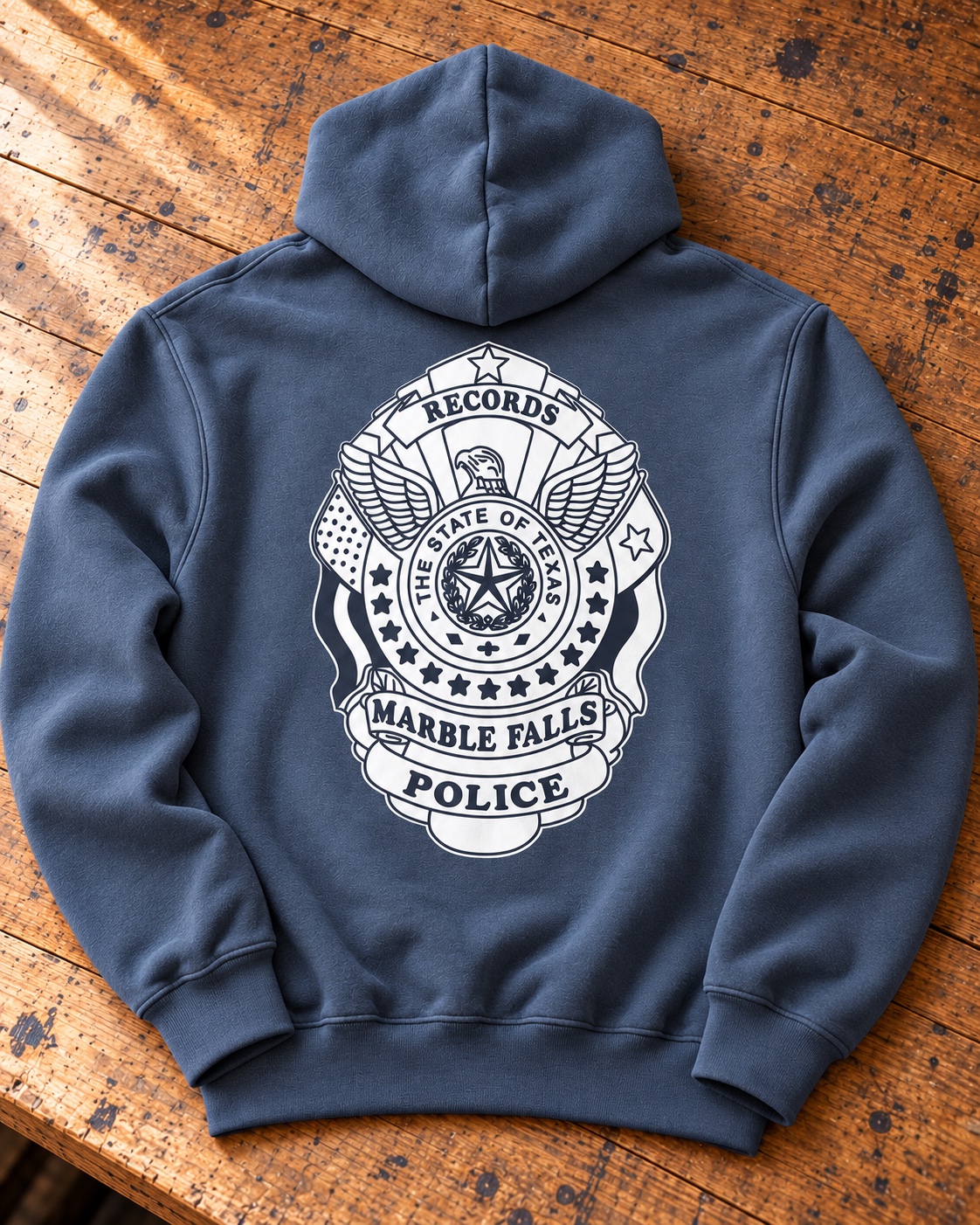 Staged slate gray-blue Marble Falls Police Department hoodie with supplied 2025 badge artwork